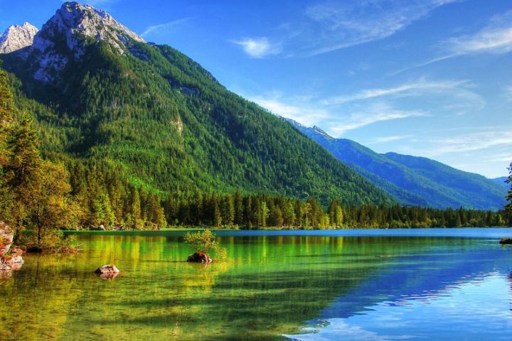 a lake surrounded by a body of water with a mountain in the background
