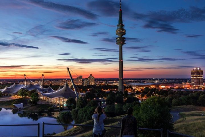 a group of people standing in front of a sunset
